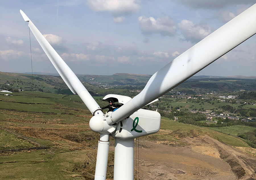 A wind turbine engineer standing in the turbine nacelle